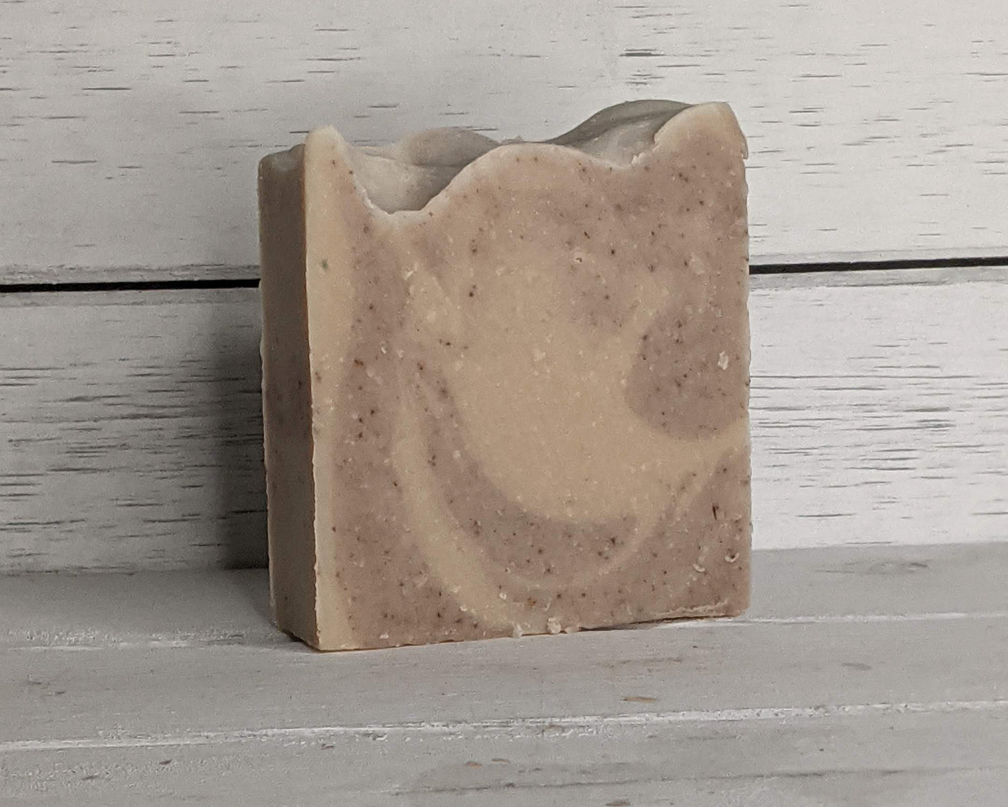 Bar of soap with a natural brown and beige color pattern on a wooden surface.