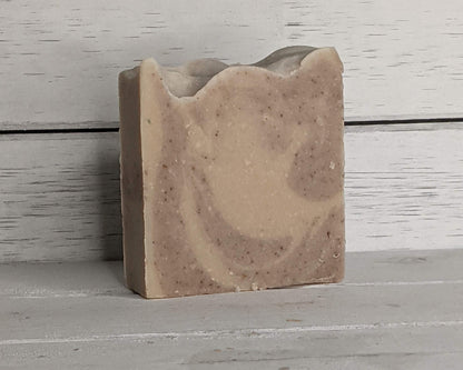 Bar of soap with a natural brown and beige color pattern on a wooden surface.